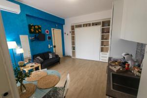 a living room with a table and a blue wall at Acitrezza Casuzza in Aci Castello