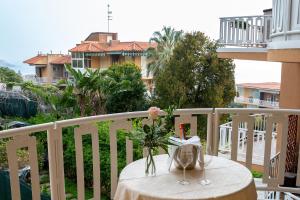 - une table avec un vase de fleurs sur le balcon dans l'établissement Acitrezza Casuzza, à Aci Castello