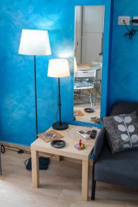 Cette chambre comprend une table avec deux lampes et un canapé. dans l'établissement Acitrezza Casuzza, à Aci Castello