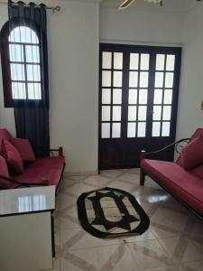 a living room with two red couches and a rug at cozy 2 bedroom apartment in Sharm El Sheikh
