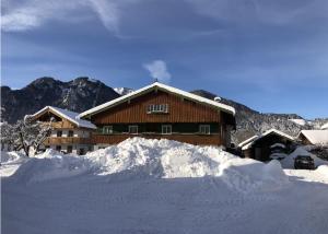 a ski lodge with a pile of snow in front of it at NEU: Alpen-Chalet Seekarblick mit Pool in Lenggries