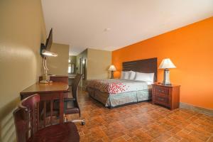 Habitación de hotel con cama, escritorio y escritorio. en Aransas Bay Inn & Suites Corpus Christi by OYO en Aransas Pass