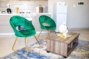 two green chairs and a table in a kitchen at Ongwe Leisure Property in Swakopmund