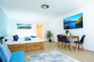 a bedroom with a bed and a table with chairs at RELAX - BLUE mit Pool und Sauna in Scheidegg