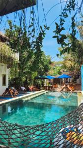 a swimming pool with people lounging around it at Tipsea Turtle Gili Air in Gili Air