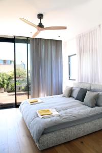 Schlafzimmer mit einem großen Bett und einem Deckenventilator in der Unterkunft 4BDR - Stunning & Magnificent Duplex Penthouse TLV in Tel Aviv