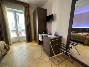 una camera d'albergo con scrivania e letto di BB 10 Serpotta & Restaurant a Palermo