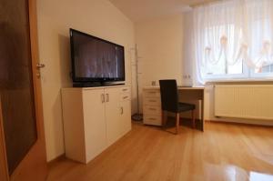 a room with a desk with a television and a chair at Alb Pension Merklingen in Merklingen