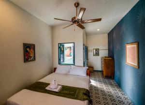 a bedroom with a bed and a ceiling fan at Susie Q Designer House in Kampot