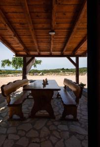 - une table et deux chaises sous un pavillon sur la plage dans l'établissement Holiday home - Villa Juli, à Šibenik