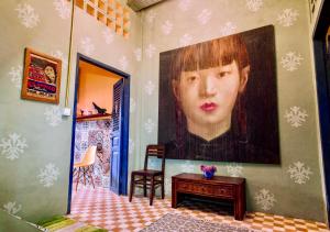 a large painting of a boy on a wall at Susie Q Designer House in Kampot