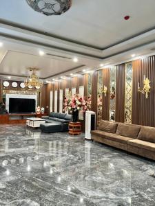 sala de estar con sofá y TV en Hương Nam Hotel en Ha Long