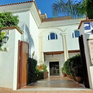 a white house with a gate and a driveway at La Luna Blanca in Torremolinos