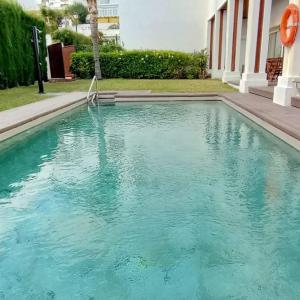 a swimming pool with blue water in front of a building at La Luna Blanca in Torremolinos