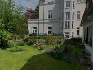 a large white house with a garden in front of it at Haus mit 110qm und Garten 150m zum Wasser in Stralsund