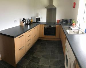 a kitchen with a black counter top and a sink at Traditional Croft house in Creagorry