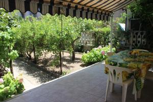 un patio con mesa y sillas en un jardín en Mille Bouganville, en Platamona