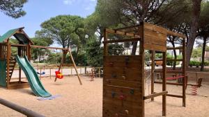 un parque infantil con 2 columpios y un tobogán en Mille Bouganville, en Platamona