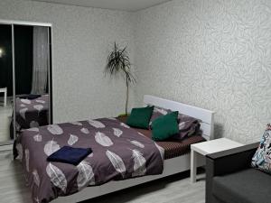ein Schlafzimmer mit einem Bett mit grünen Kissen darauf in der Unterkunft 2 комнаты в центре Солнечная галлерея,Мэтро,Сильпо,КБ75 Тысячка in Krywyj Rih