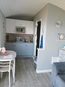 eine Küche und ein Esszimmer mit einem Tisch und einem Esszimmer in der Unterkunft Allibella Shepherds Hut, Amazing Seaview, Private garden, Pet Friendly in Barmouth