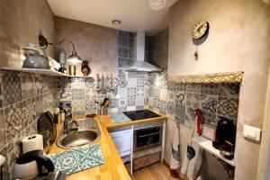 uma pequena cozinha com um lavatório e um fogão em L'Aristoloche em Salins-les-Bains