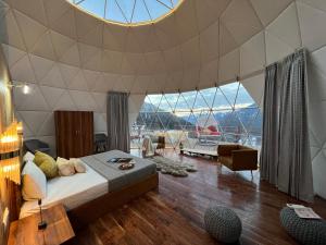 una camera con un letto e un grande soffitto in vetro di GLAMPING CLUB a Manāli