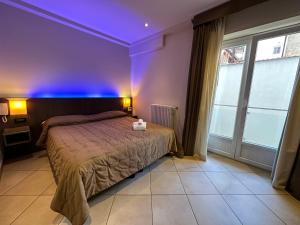 Un dormitorio con una cama con luces moradas. en BB 10 Serpotta & Restaurant, en Palermo