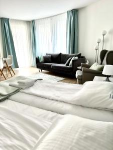 a bedroom with a large bed and a couch at AL-DOM apartamenty Olymp 109 in Kołobrzeg