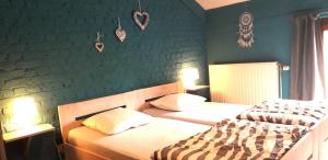 dwa łóżka w sypialni z zielonymi ścianami w obiekcie L'orée du bois w mieście Roy