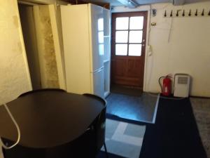 um quarto com uma mesa, um frigorífico e uma porta em Københavnsvej em Roskilde
