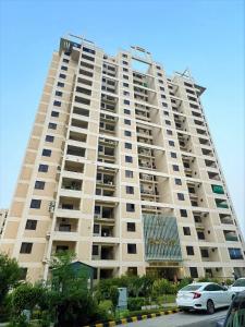 um grande edifício de apartamentos com carros estacionados em frente em The Realtors Inn 1 BDR Apartment DHA 2 em Islamabad