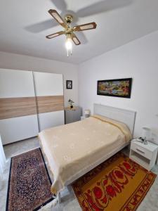 a bedroom with a bed and a ceiling fan at LiriKa's airport house in Artemida