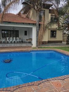 a large blue swimming pool in front of a house at Entire 4 bedroom house in Midrand, Johannesburg in Randjesfontein