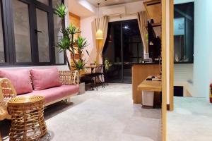 ダナンにあるURI HOUSE, 1-2 BR tourism apt, 5' walk Dragon Bridgeのリビングルーム(ピンクのソファ、テーブル付)