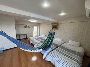 a room with three beds and a hammock at 長楽園 in Shirahama