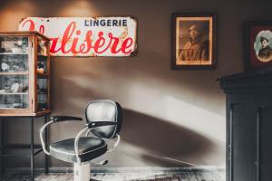 a chair in a room with a sign on the wall at Vakantiehuis Juliette in Diksmuide