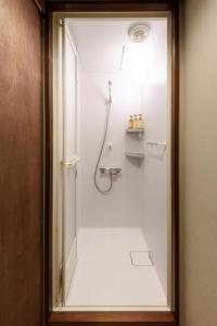 a bathroom with a shower with a glass door at Hotel New Moustache in Shizuoka