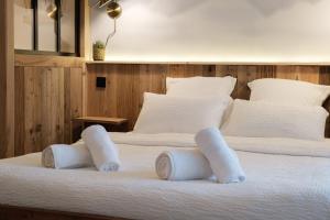 2 bedden in een slaapkamer met witte lakens en kussens bij Studio Emeraude - Centre Village - AravisTour in Saint-Jean-de-Sixt