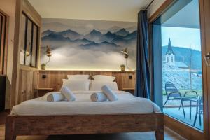 een slaapkamer met een groot bed en een muurschildering van de bergen bij Studio Emeraude - Centre Village - AravisTour in Saint-Jean-de-Sixt