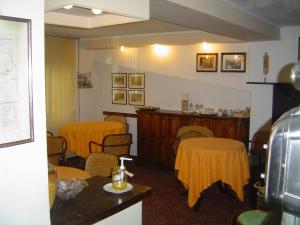 a waiting room with chairs and tables and a bar at Bridge Hotel in Bagni di Lucca