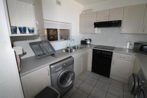 a kitchen with a sink and a washing machine at Chesapeake Bay 17 in Margate
