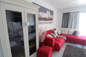 a living room with a red couch and a red chair at Chesapeake Bay 17 in Margate