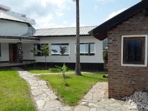 ein Haus mit einem Rasenplatz neben einem Gebäude in der Unterkunft Pazuri House Iringa in Iringa