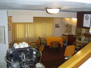 uma sala de jantar com mesa e cadeiras e uma sala com mesa e cadeiras em Bridge Hotel em Bagni di Lucca