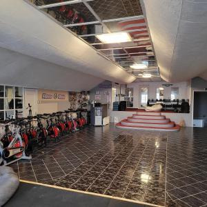 un gimnasio con filas de bicicletas estáticas en una habitación en KOMPLEX -Rendezvénytermek-Panzió-Apartman-Irodák-, en Mátészalka