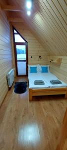ein Schlafzimmer mit einem Bett in einer Holzhütte in der Unterkunft Sołtysie Chaty - Domek z prywatną balią in Łapsze Niżne