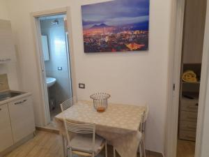 a table and chairs in a kitchen with a painting on the wall at Flaviogioia Apartment in Naples