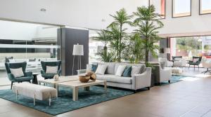 a living room with a couch and chairs and a table at Ilunion Calas de Conil in Conil de la Frontera