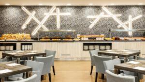 a restaurant with tables and chairs and a counter with food at Ilunion Calas de Conil in Conil de la Frontera