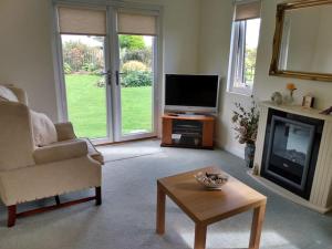 a living room with a television and a coffee table at Coastal Garden Lodge in Preesall